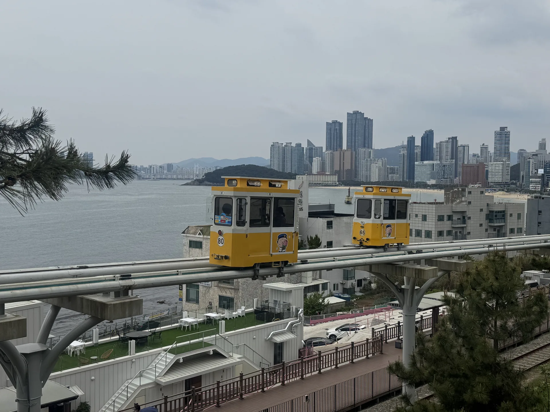 A pastel Sky Capsule cabin on the elevated coastal track at Haeundae Blue Line Park, Busan